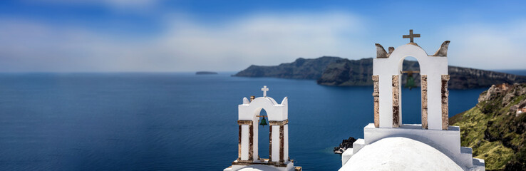 Wall Mural - Santorini, Greece. Panorama of Greek Orthodox Church with bellfry in Oia village, aerial view.