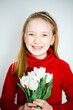 © Анна Молько - beautiful little girl in a red sweater on a white background with a bouquet of tulips. congratulations on mother's day