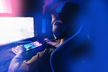 Poster - Streamer young man professional gamer playing online games computer with headphones, neon color