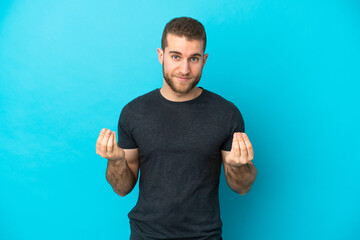 Poster - Young handsome caucasian man isolated on blue background making money gesture but is ruined