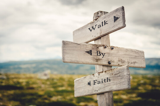 Wall Mural - walk by faith text quote written in wooden signpost outdoors in nature. Moody theme feeling.