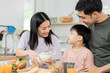 © KMPZZZ - Happy refreshment family breakfast in morning, asian young parent father, mother and little cute boy, child having meal in kitchen eating together at home. Cheerful, enjoy cooking people.