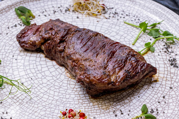 Sticker - roast beef Steak machete on grey plate on dark stone table side view macro close up