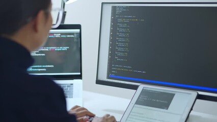 Young Asian woman, developer programmer, software engineer, IT support, wearing glasses working on computer to check coding in bugging system. Back view