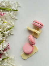 Pink Macaroons And White Chocolate With Hyacinth On White Background