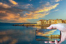 Man Taking A Landscape Photograph On A Cell Phone On Vacation