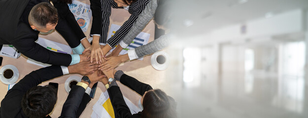 Wall Mural - Happy business people celebrate teamwork success together with joy at office table shot from top view . Young businessman and businesswoman workers express cheerful victory in broaden view .