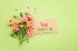 © tomertu - mother's day concept with pink flowers over green wooden background