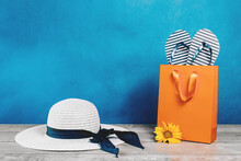 Summer Vacation. Flowers In A Bag With Marine Flip Flops. White Summer Hat On A Table. Seaside Travel Concept