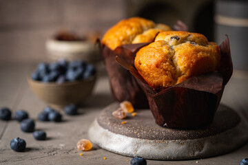 Sweet homemade pastries muffin with blueberries and fresh berries on stone background.