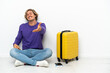 © luismolinero - Young blonde man with suitcase sitting on the floor shaking hands for closing a good deal