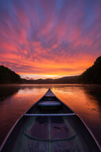 Colorful Sunset After Passing Storm From An Old Aluminum Canoe On Mountain Lake