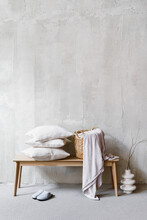 Pillows And Wicker Laundry Basket With Bedding On Bench