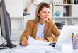 © JackF - positive woman working on her laptop in white room