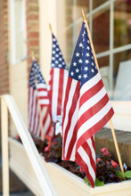 American Flags In A Flower Planter In Front A Store Window. Window.
