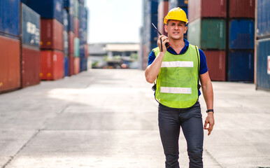 Wall Mural - Professional engineer container cargo foreman in helmets working standing and using walkie talkie checking stock into container for loading.logistic transport and business industry export