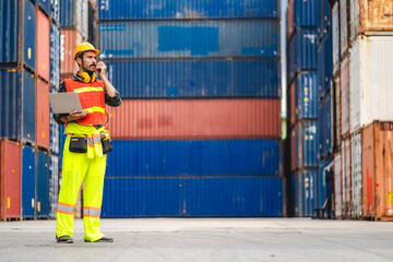 Wall Mural - Professional engineer container cargo foreman in helmets working standing and using walkie talkie checking stock into container for loading.logistic transport and business industry export