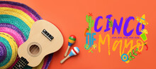 Mexican Sombrero Hat, Guitar, Maracas And Text CINCO DE MAYO (Fifth Of May) On Orange Background