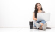 © chalongrat - Beautiful Asian woman wearing grey casual shirt using laptop on white background and copy space. Cute Asian woman sitting on the floor room relaxing  for work from home concept