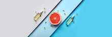 Cosmetic Bottles With Vitamins And Grapefruit Slice On Color Background. Banner For Design