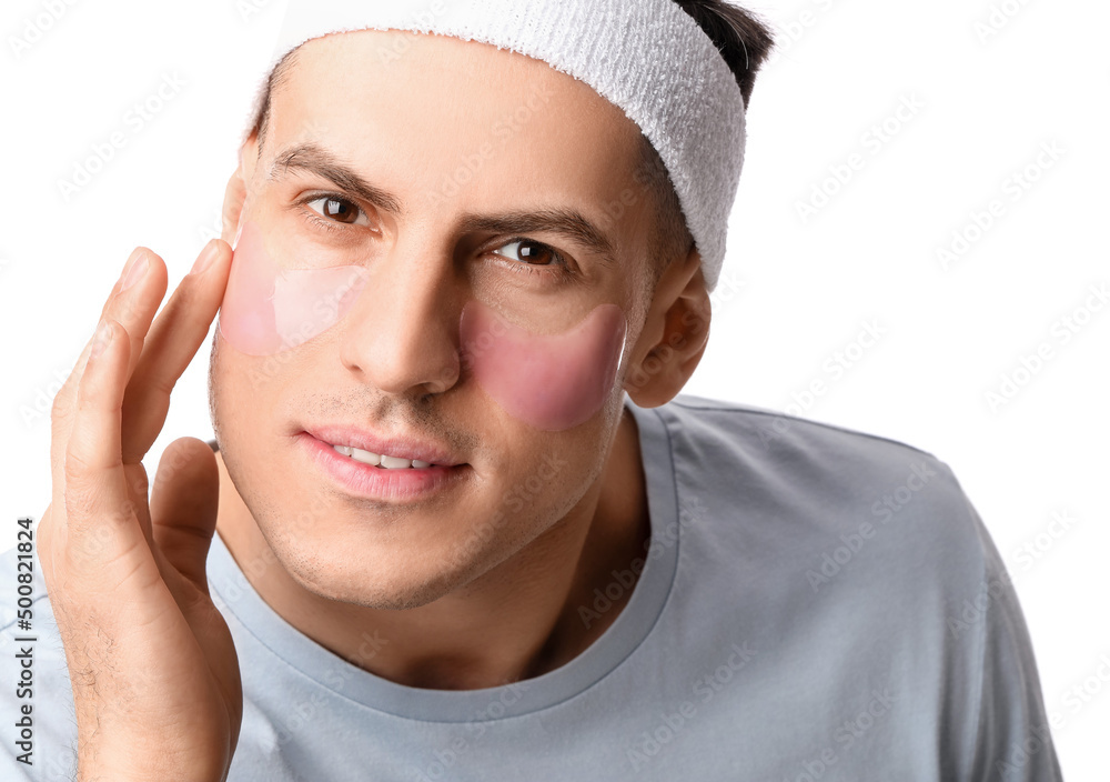 Handsome man with under-eye patches on white background, closeup