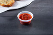 © DAVID - A view of a condiment cup of marinara sauce.