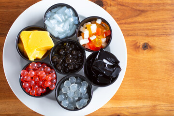 Wall Mural - A top down view of a plate holding a variety of popular milk tea toppings and ingredients.