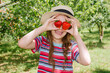 © NATALYA - Little kid girl eating red strawberry in nature. Child enjoys a delicious berry.
