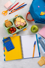 Wall Mural - Healthy school lunch box with sandwich and salad on the workplace near backpack. School supplies, books, apple and a bottle of water.