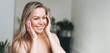 Blonde smiling woman with long hair does facial massage in underwear at bathroom, banner