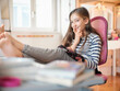 © Westend61 - Smiling girl with diary sitting on chair at home