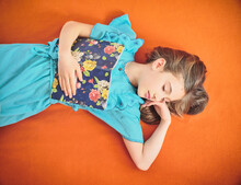 Girl With Book Sleeping On Orange Background