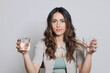 © Westend61 - Beautiful woman holding glasses of water against gray background