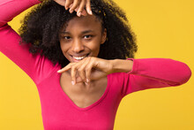 Smiling Young Woman Gesturing Against Yellow Background