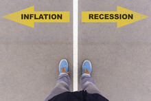 Inflation Or Recession Choice, Text On Asphalt Ground, Feet And Shoes On Floor