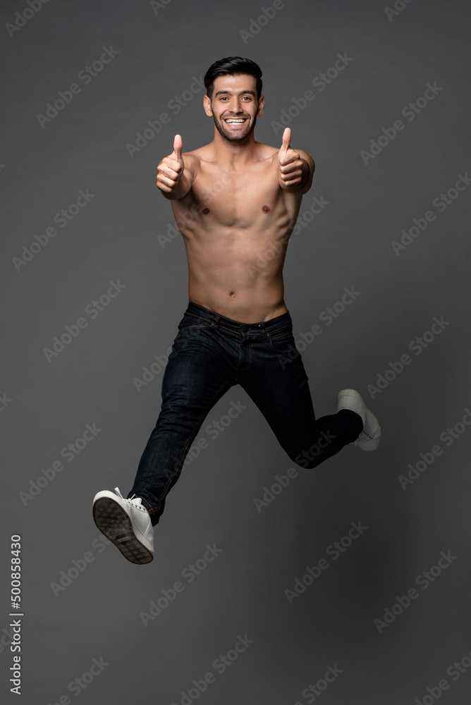 Energetic andsome shirtless Caucasian man jumping and giving thumbs up ...