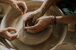 © Westend61 - Hands of Instructor teaching young man molding bowl on potter's wheel in workshop