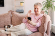 © Tatyana Gladskih - mature old 60s woman holding smartphone using mobile phone app for video call