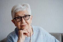 Smiling Senior Woman With Hand On Chin At Home