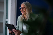 Contemplative Businesswoman With Eyeglasses Holding Tablet PC