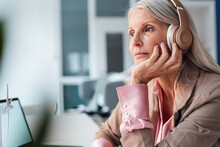 Businesswoman Listening Music Through Headphones At Office