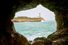 Portocolom Lighthouse On Cliff Seen From Cave