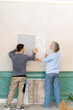 © Westend61 - Woman and friend choosing wallpaper from samples on white wall