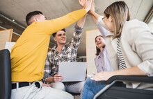 Happy Business People High Fiving In Office