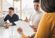 © Westend61 - Young business people discussing a document during a meeting in office