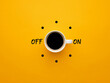 Coffee cup switch on off concept on yellow background. Morning wake up coffee break concept.