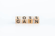 turn loss into gain concept, wooden cube with word LOSS flip to GAIN. capital investment gain and loss, financial while managing assets e.g. bonds, stocks, derivatives, ETFs, Crypto currency, forex