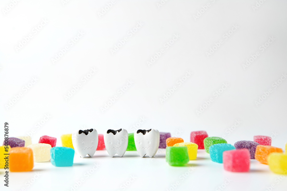 Decay tooth and cubes sweet sugar candy on white background, eat sweet ...