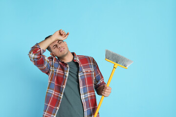 Sticker - Tired man with yellow broom on light blue background