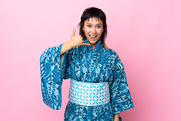 Wall Mural - Young woman wearing kimono over isolated blue background making phone gesture. Call me back sign